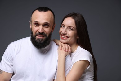 Portrait of happy daughter and father on dark grey background