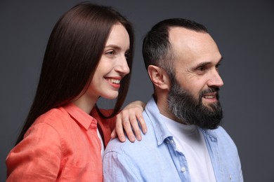 Happy daughter and father on dark grey background