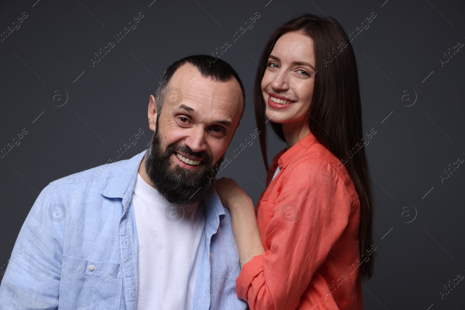 Photo of Portrait of happy daughter and father on dark grey background