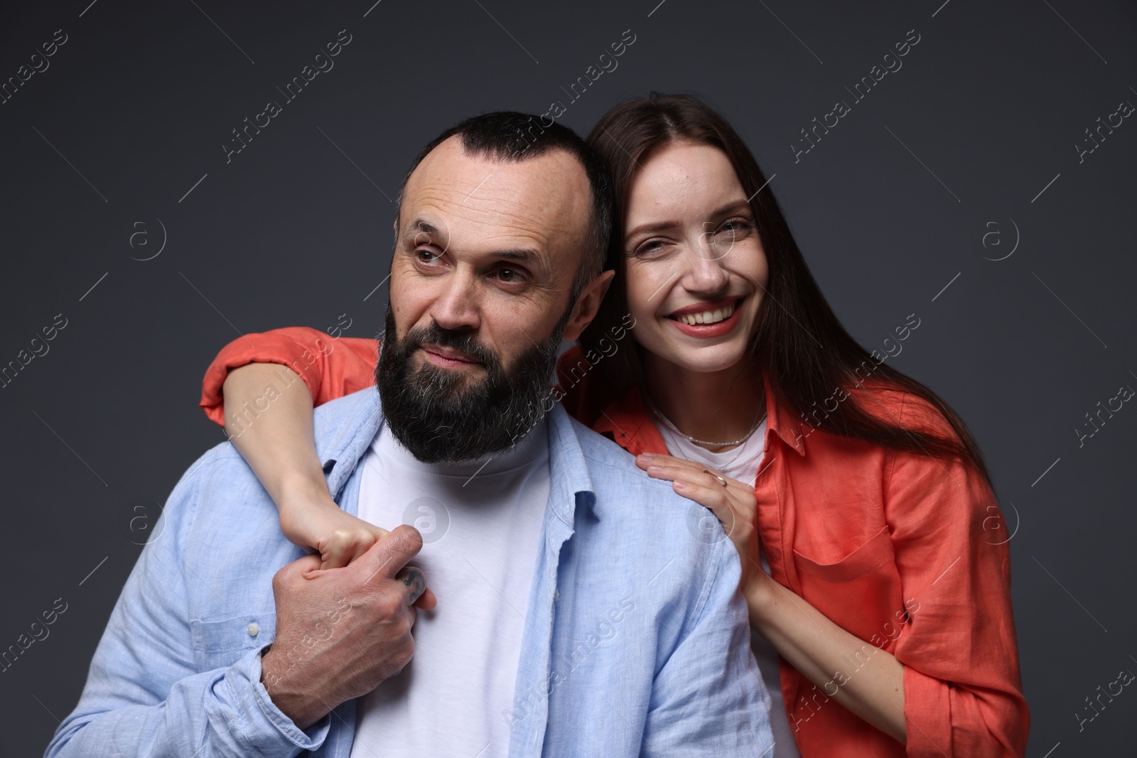 Photo of Happy daughter and father on dark grey background