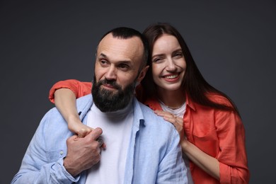 Photo of Happy daughter and father on dark grey background