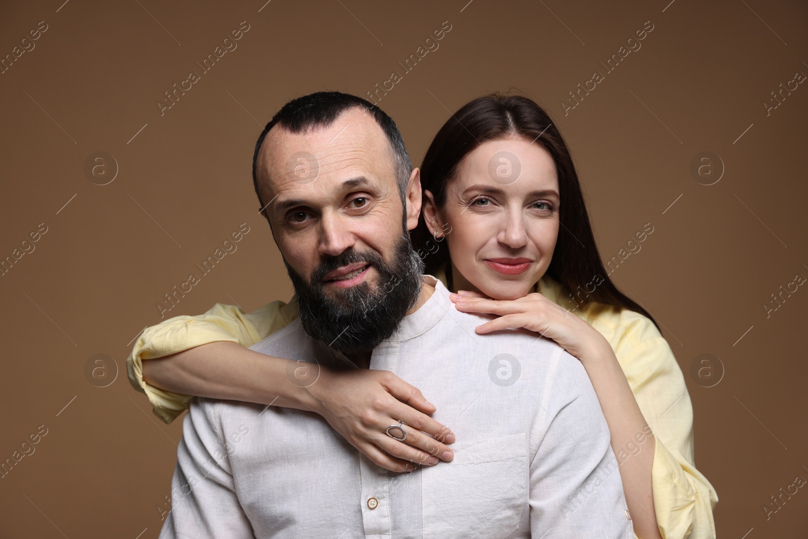 Photo of Portrait of happy daughter and father on brown background