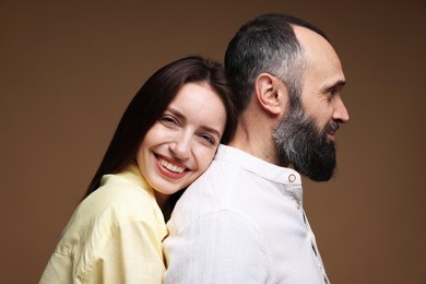 Photo of Happy daughter and father on brown background