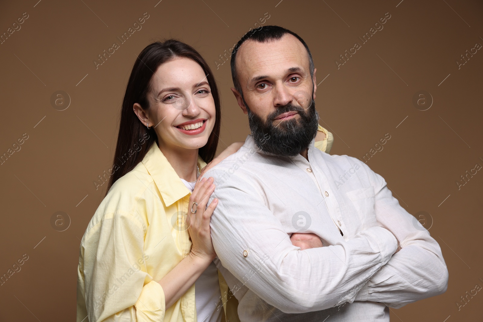 Photo of Portrait of happy daughter and father on brown background