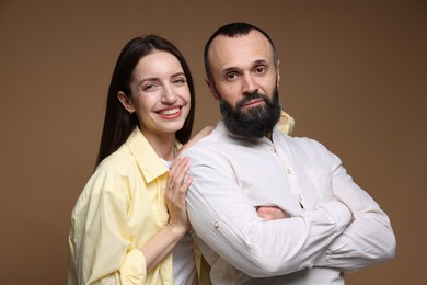 Portrait of happy daughter and father on brown background