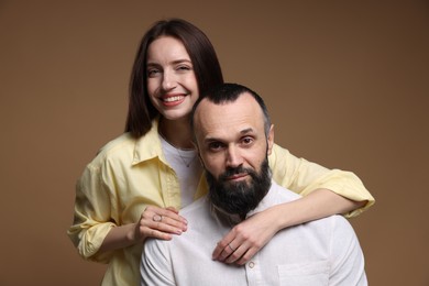 Portrait of happy daughter and father on brown background