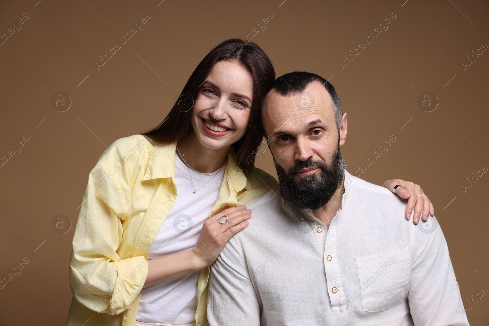 Photo of Portrait of happy daughter and father on brown background