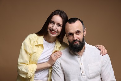 Portrait of happy daughter and father on brown background