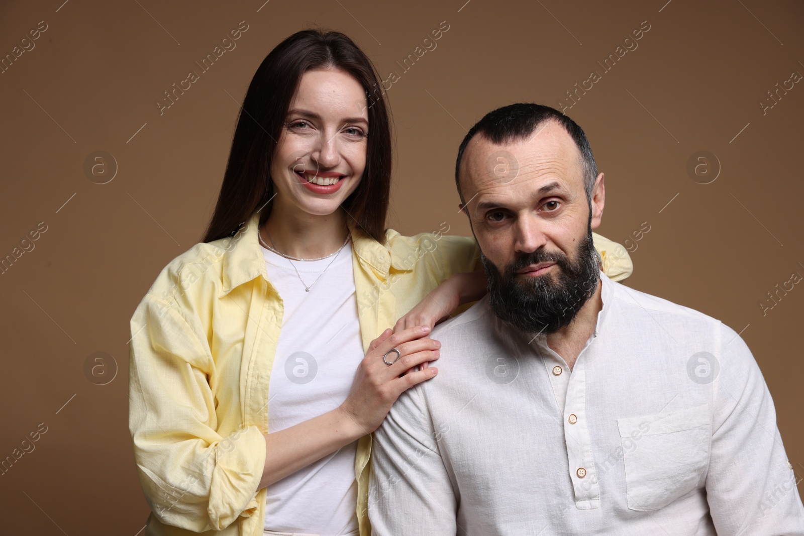 Photo of Portrait of happy daughter and father on brown background