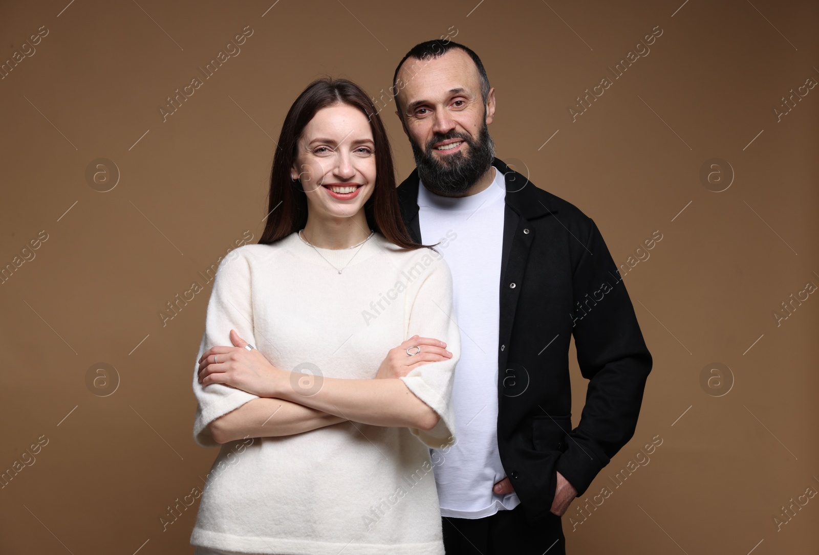 Photo of Portrait of happy daughter and father on brown background