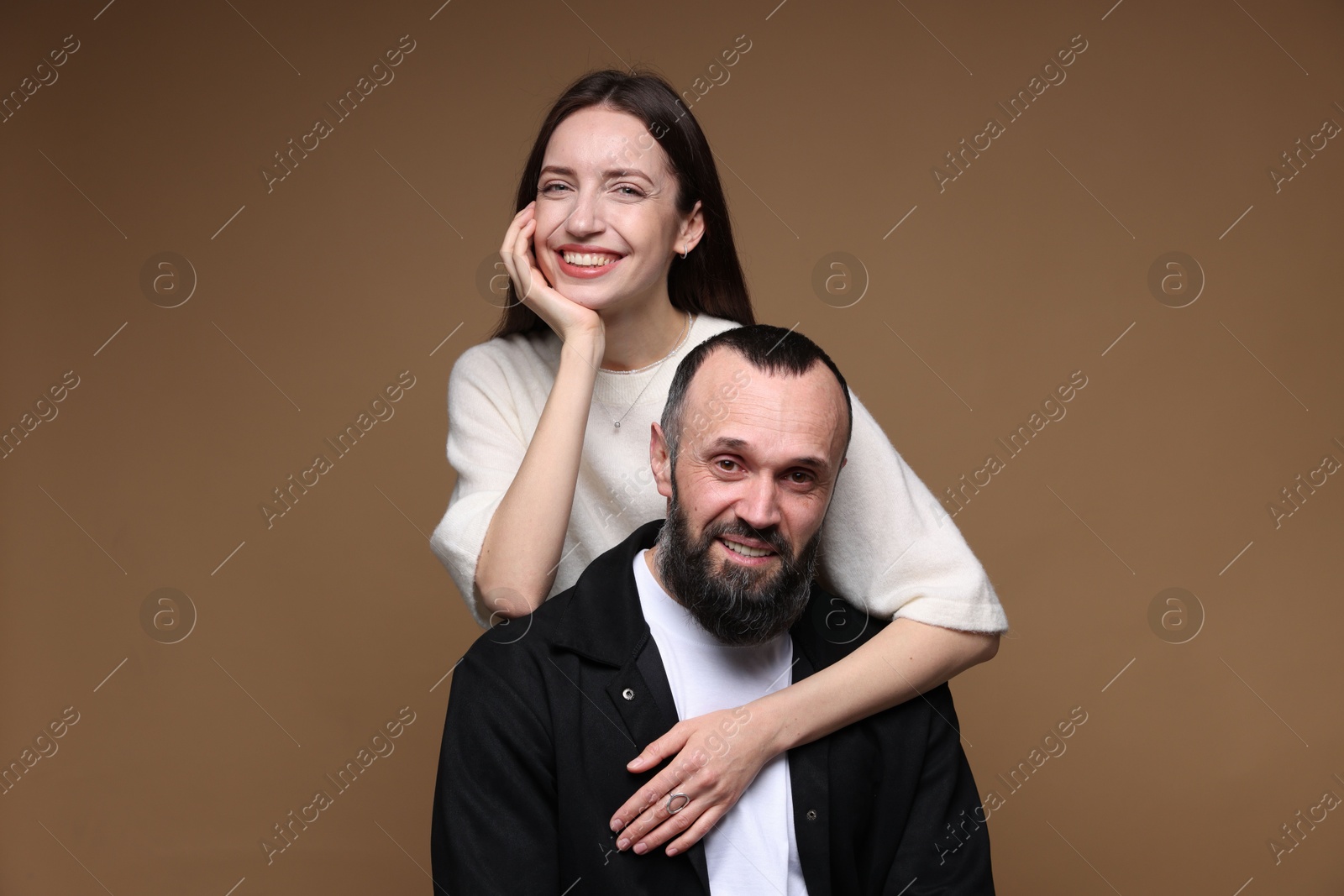 Photo of Portrait of happy daughter and father on brown background