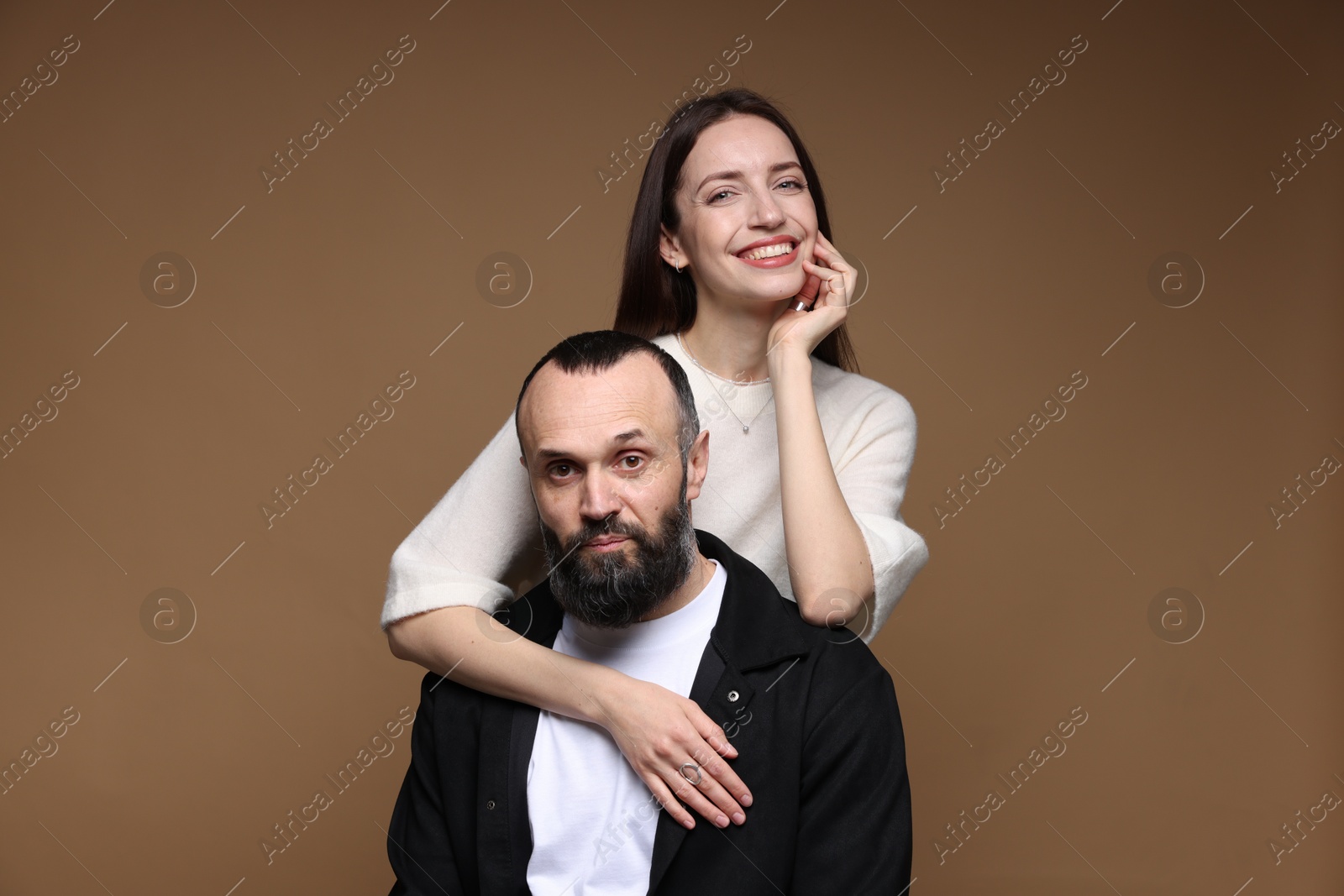 Photo of Portrait of happy daughter and father on brown background