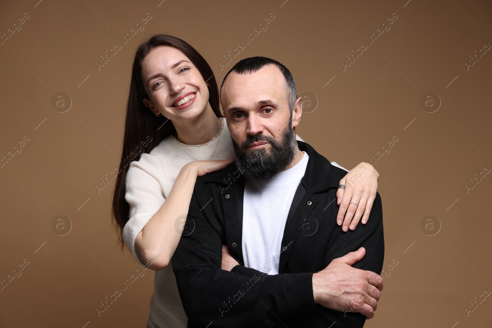 Photo of Portrait of happy daughter and father on brown background