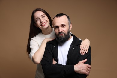 Portrait of happy daughter and father on brown background