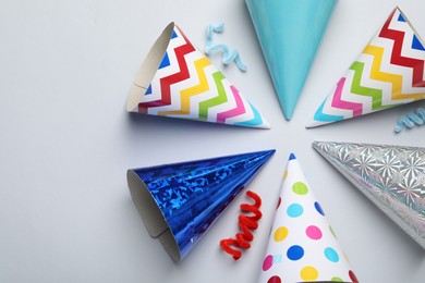 Photo of Colorful party hats on light grey background, flat lay