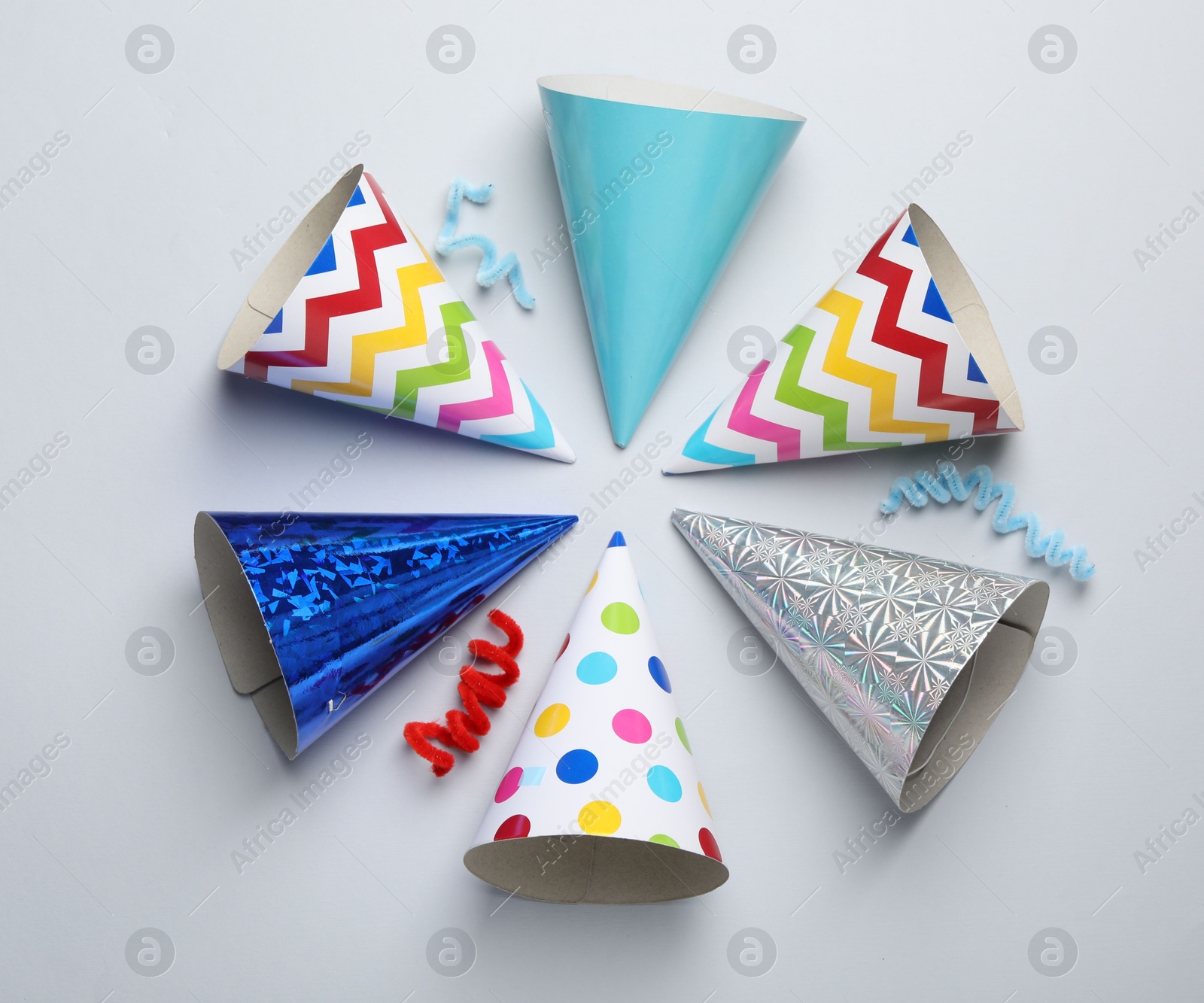 Colorful party hats on light grey background, flat lay Photo of Colorful party hats on light grey background, flat lay