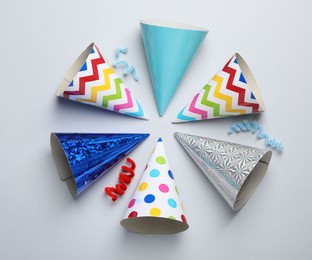 Photo of Colorful party hats on light grey background, flat lay