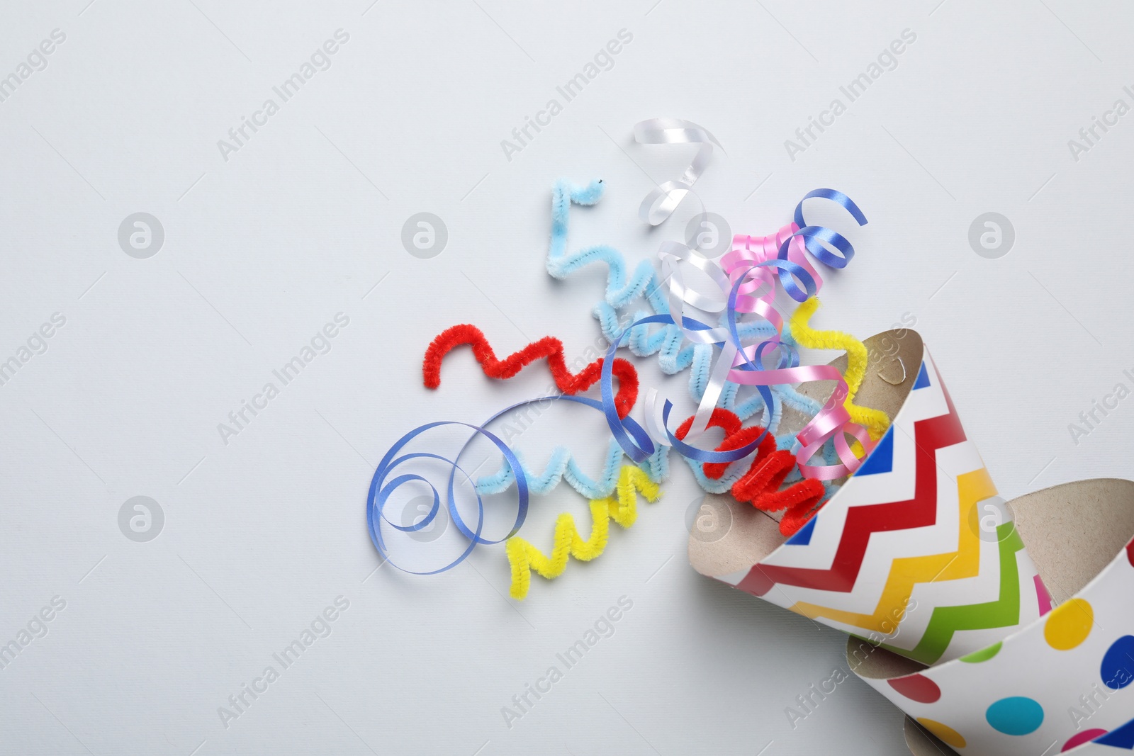 Colorful party hats and streamers on light grey background, flat lay. Space for text Photo of Colorful party hats and streamers on light grey background, flat lay. Space for text
