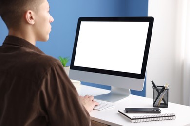 Man working on computer at white desk in office. Mockup for design