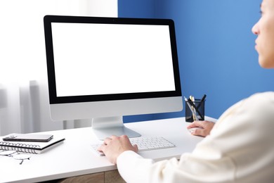 Man working on computer at white desk in office, closeup. Mockup for design