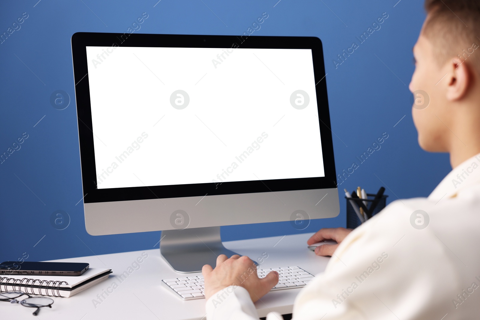 Photo of Man working on computer at white desk in office, closeup. Mockup for design