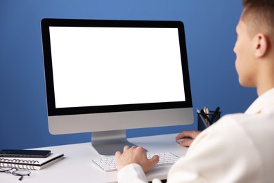 Man working on computer at white desk in office, closeup. Mockup for design