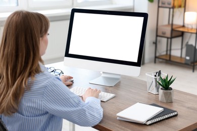 Woman working on computer at wooden desk in office. Mockup for design