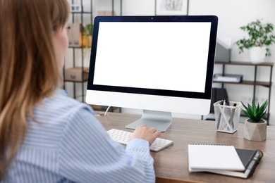 Woman working on computer at wooden desk in office. Mockup for design