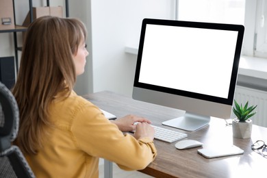 Woman working on computer at wooden desk in office. Mockup for design