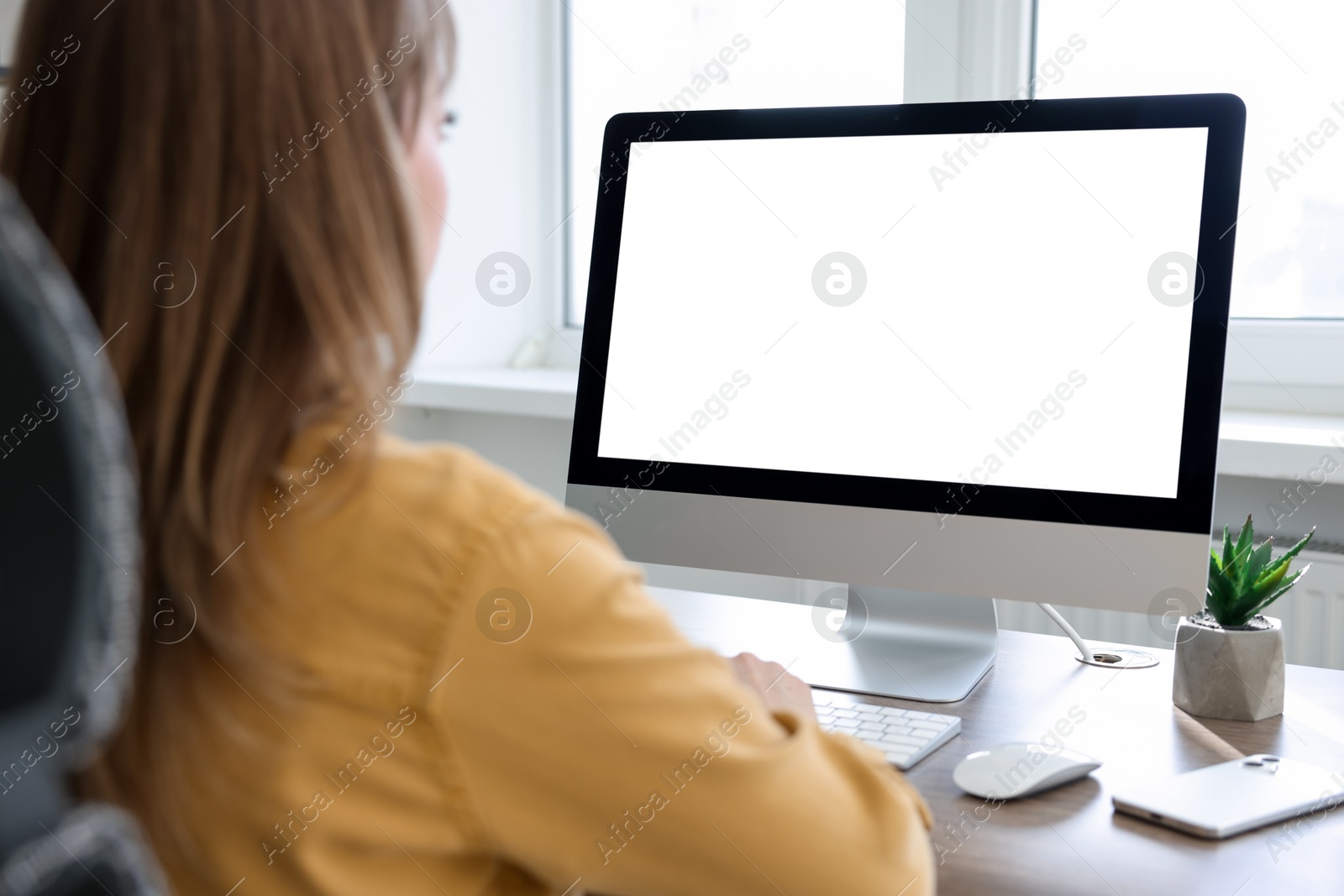 Photo of Woman working on computer at desk in office. Mockup for design