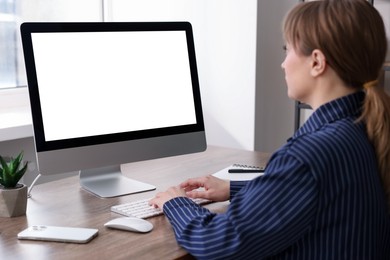 Photo of Woman working on computer at wooden desk in office. Mockup for design