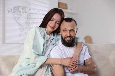 Happy daughter and father on sofa at home