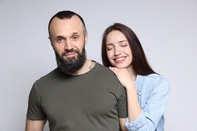 Happy daughter and father on light grey background