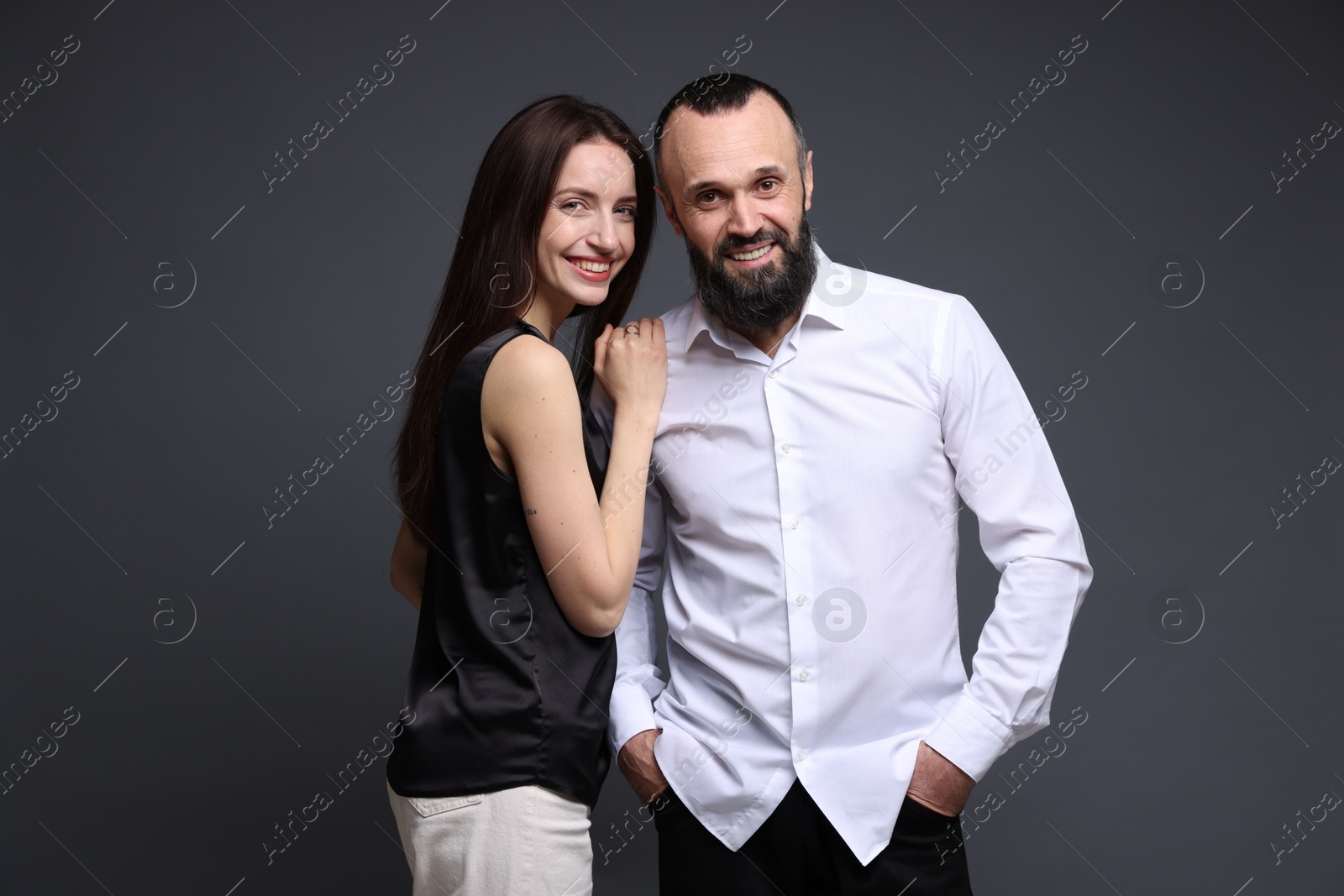 Photo of Portrait of happy daughter and father on dark grey background