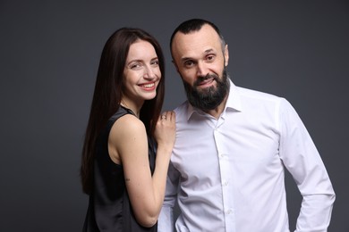 Portrait of happy daughter and father on dark grey background