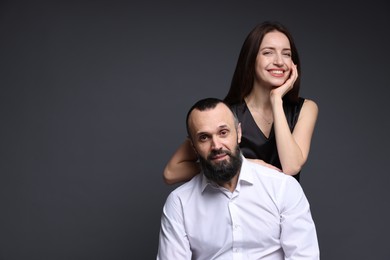 Photo of Portrait of happy daughter and father on dark grey background. Space for text