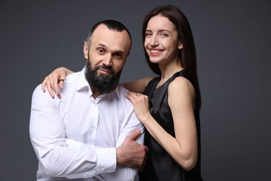 Portrait of happy daughter and father on dark grey background