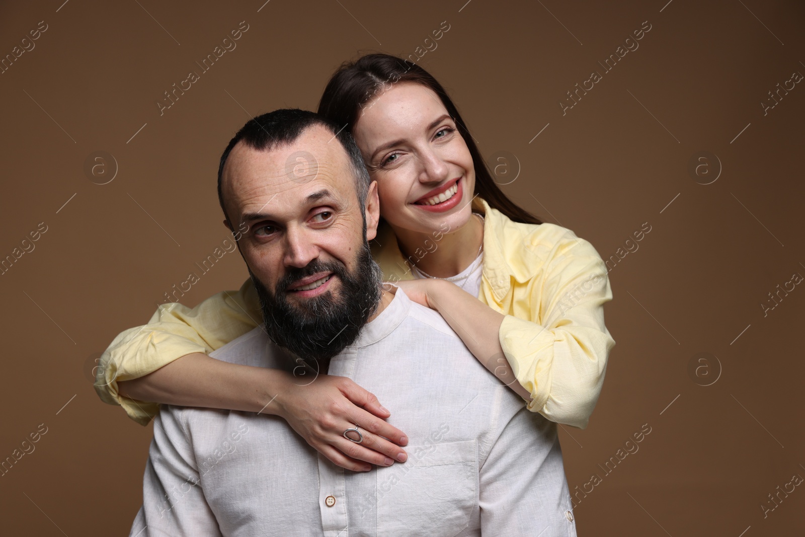 Photo of Portrait of happy daughter and father on brown background