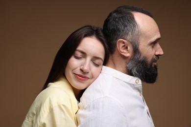 Photo of Happy daughter and father on brown background