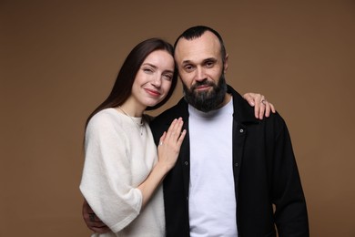 Photo of Portrait of happy daughter and father on brown background