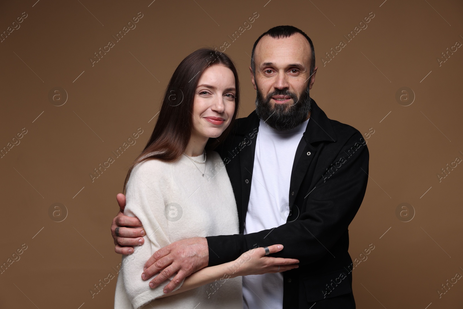 Photo of Portrait of happy daughter and father on brown background