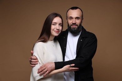 Portrait of happy daughter and father on brown background