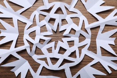 Photo of One paper snowflake on wooden background, top view