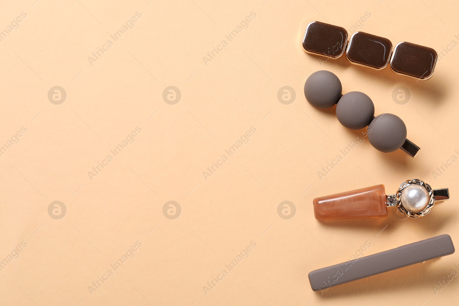 Beautiful hair clips on beige background, flat lay. Space for text Photo of Beautiful hair clips on beige background, flat lay. Space for text