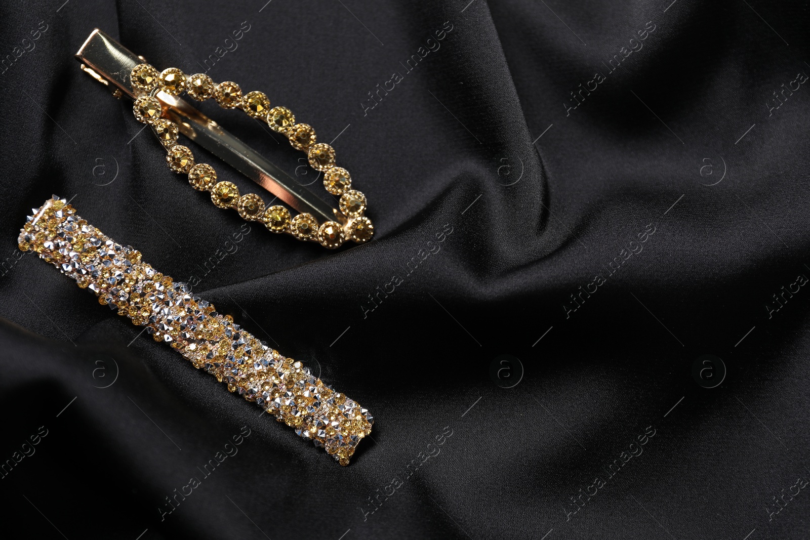 Beautiful hair clips on black fabric, flat lay. Space for text Photo of Beautiful hair clips on black fabric, flat lay. Space for text