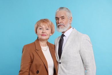 Portrait of lovely senior couple on light blue background