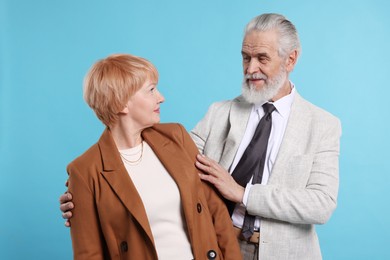 Lovely senior couple on light blue background