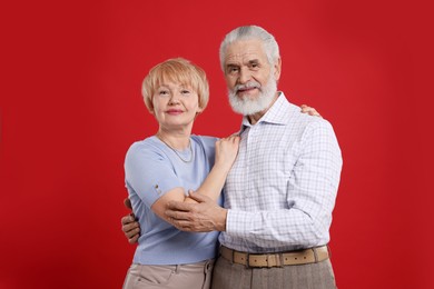 Photo of Portrait of lovely senior couple on red background