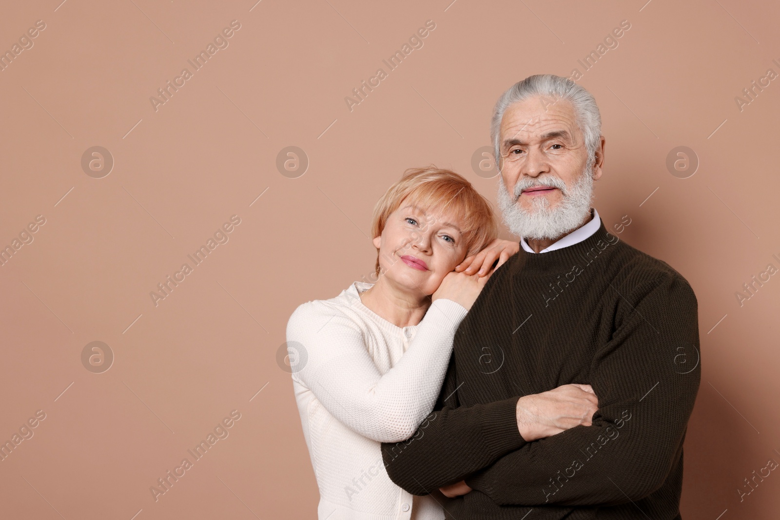 Photo of Portrait of lovely senior couple on beige background. Space for text