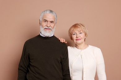 Portrait of lovely senior couple on beige background